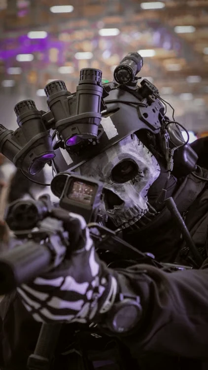 Jugador de airsoft con casco táctico, visor nocturno y máscara de calavera