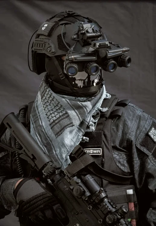 Jugador de airsoft con casco, visor nocturno y pañoleta táctica